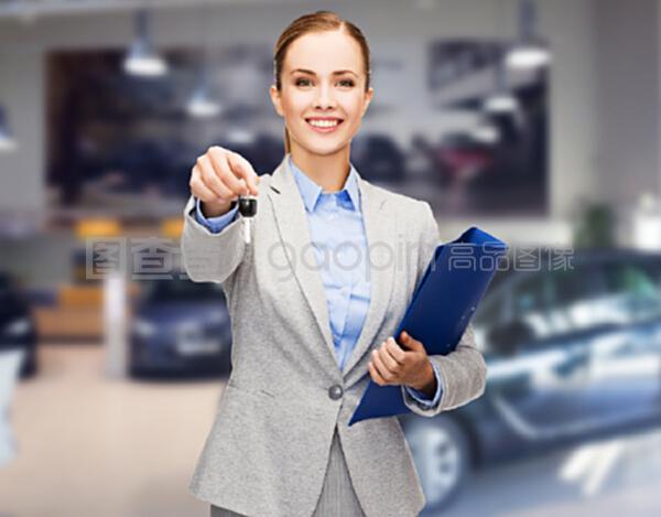 汽車業(yè)務(wù),汽車銷售,手勢和人的概念-快樂的女商人或售貨員與文件夾給車鑰匙在汽車展示背景